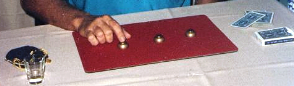 Magician Chaz Misenheimer performs the Three Shell Game for guests around a magic table